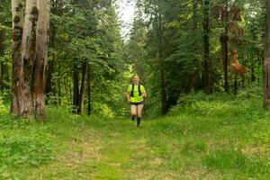 young woman jogging on a trail in a natural forest park photo