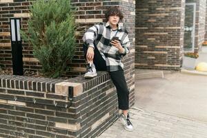 young man in cityscape sitting on curb photo