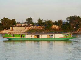 lento barco crucero a lo largo el mekong río, local barco Moviente en mekong río Entre el frontera de Tailandia y Laos, barco transporte en el río, transporte Embarcacion foto