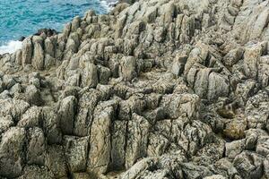 natural stone background, the remains of lava basalt columns form a kind of steps on a seashore photo