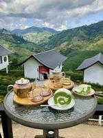 tea from glass teapot on wooden serving tray, hands pouring tea from teapot, Cropped shot of pouring tea in traditional chinese tea ware, piece of white cake photo