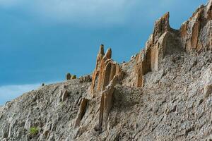 upper edge of jagged rock wall against the sky photo