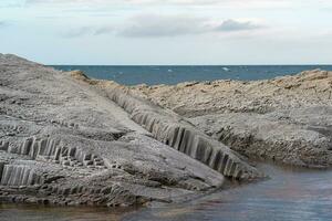 coastal seascape with beautiful columnar basalt rocks at low tide photo