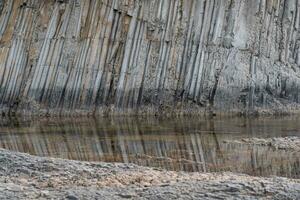 natural paisaje con de columna basalto costero rock reflejado en el agua foto