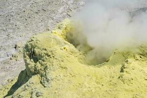 smoking vent of a solfatara in a fumarole field on a slope of the volcano photo