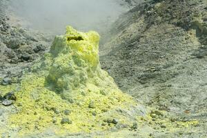 sulfur deposits around a solfatara in a fumarole field on the slope of a volcano photo