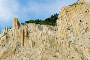 alto costero acantilado hecho de de columna granito, paisaje en el isla de kunashir foto