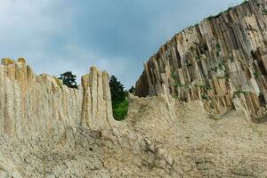 high coastal cliff made of columnar granite, landscape on the island of Kunashir photo