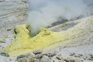 steaminf fumarola in a solfataric field on a slope of the volcano photo