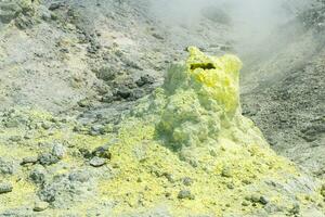 cone of sulfur deposits around a fumarole in a solfataric field photo