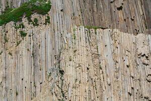 natural background, rock surface formed by vertical basalt columns photo