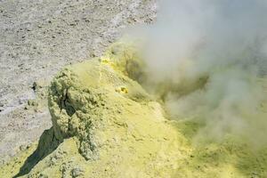 steaminf fumarola in a solfataric field on a slope of the volcano photo