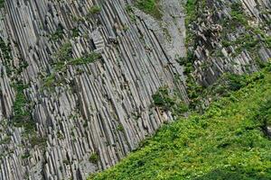 natural background, rock surface formed by vertical basalt columns photo