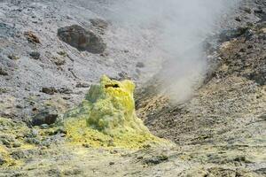 cone of sulfur deposits around a fumarole in a solfataric field photo