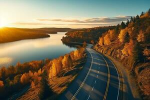 ai generado aéreo ver de montaña la carretera en bosque a puesta de sol en otoño. parte superior ver desde zumbido de la carretera en bosque. hermosa paisaje con calzada en sierras, pino árboles, verde prados foto