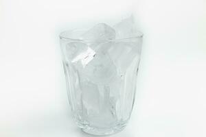 Ice cubes in glass isolated on white background, shallow depth of field photo