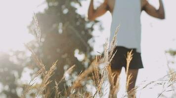 sportlich Läufer tun Dehnen Übung, vorbereiten zum Laufen im das Natur mit das Stadt im Hintergrund. gesund Lebensstil video