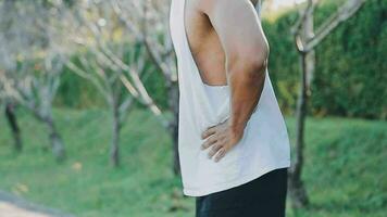 Athletic runner doing stretching exercise, preparing for running in the nature with the city in background. Healthy lifestyle video