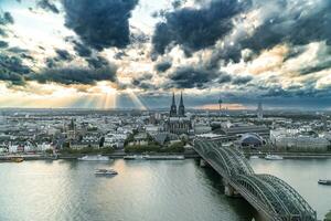 dramático tormenta nubes terminado Colonia catedral y hohenzollern puente en el puesta de sol foto