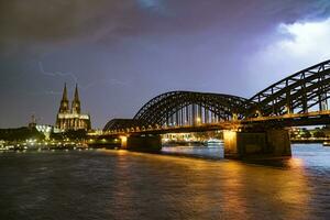 relámpago y dramático tormenta nubes terminado Colonia catedral y hohenzollern puente foto