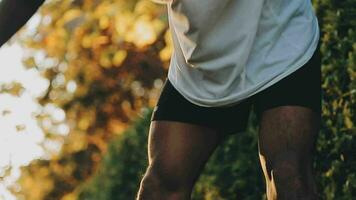 atletisk löpare håller på med stretching träning, framställning för löpning i de natur med de stad i bakgrund. friska livsstil video