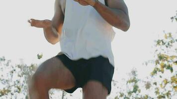 Athletic runner doing stretching exercise, preparing for running in the nature with the city in background. Healthy lifestyle video