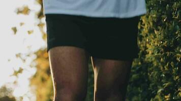 Athletic runner doing stretching exercise, preparing for running in the nature with the city in background. Healthy lifestyle video