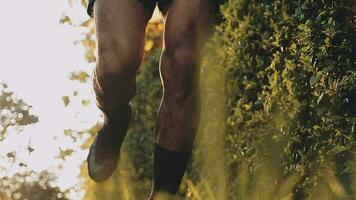 Athletic runner doing stretching exercise, preparing for running in the nature with the city in background. Healthy lifestyle video