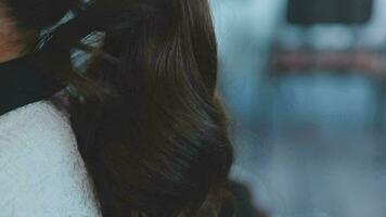 lindo Penteado do jovem mulher depois de tingimento cabelo e fazer luzes dentro cabelo salão. video