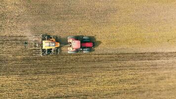 Aerial top view Tractor with plough on agricultural land, Tractor Plowing Field in Farming Landscape video