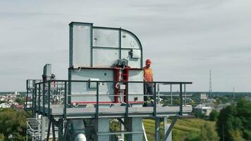 antenne visie industrieel lucht filtratie eenheid, groot lucht filtratie eenheid Aan een metaal structuur. een ingenieur inspecteert een metaal structuur Bij een hoogte. video