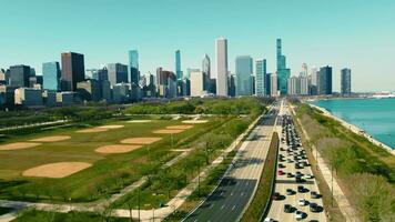 CHICAGO, USA - April 3, 2023 Aerial view Downtown Chicago and Lake Michigan on a sunny day. Vehicle traffic per day moving along the highway video