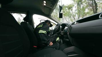 profissional motorista mulher iniciando veículo, uma profissional motorista dentro a de engenheiro uniforme obtendo para dentro a veículo, pronto para começar dele mudança. video