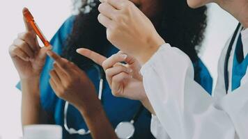 Jeune scientifiques conduite recherche enquêtes dans une médical laboratoire, une chercheur dans le premier plan est en utilisant une microscope video