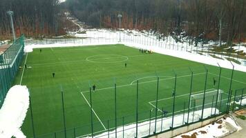 un' calcio campo nel inverno a partire dal un' uccelli occhio Visualizza. addestramento, riscaldamento e in esecuzione di calcio Giocatori. video