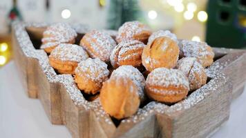 galletas nueces rociado con en polvo azúcar, girar, rodeado por luces. Navidad galletas en el formar de nueces mentira en un giratorio plataforma. video