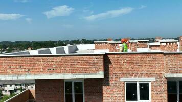 ingegneri e architetti camminare su il tetto di il edificio e ispezionare il costruzione luogo. maschio e femmina costruzione lavoratori ispezionare costruzione. video