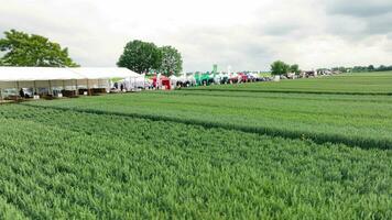 Ukraine. Brody 20.07.2023. Scenic Beauty of Nature and Culture. Tents and attendees at an agricultural fair set up in a vast, vibrant green field video