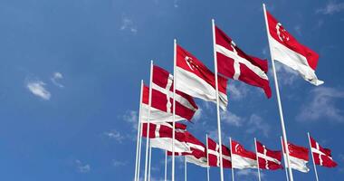 Dinamarca y Singapur banderas ondulación juntos en el cielo, sin costura lazo en viento, espacio en izquierda lado para diseño o información, 3d representación video