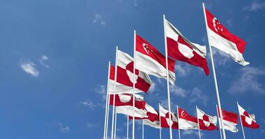Groenlandia e Singapore bandiere agitando insieme nel il cielo, senza soluzione di continuità ciclo continuo nel vento, spazio su sinistra lato per design o informazione, 3d interpretazione video