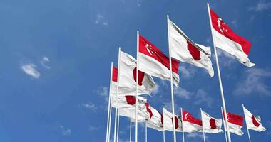 Giappone e Singapore bandiere agitando insieme nel il cielo, senza soluzione di continuità ciclo continuo nel vento, spazio su sinistra lato per design o informazione, 3d interpretazione video