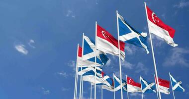 Schottland und Singapur Flaggen winken zusammen im das Himmel, nahtlos Schleife im Wind, Raum auf links Seite zum Design oder Information, 3d Rendern video