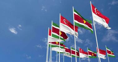 Suriname and Singapore Flags Waving Together in the Sky, Seamless Loop in Wind, Space on Left Side for Design or Information, 3D Rendering video