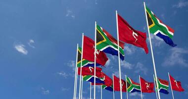 île de homme et Sud Afrique drapeaux agitant ensemble dans le ciel, sans couture boucle dans vent, espace sur la gauche côté pour conception ou information, 3d le rendu video