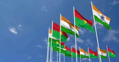 Burkina faso en Indië vlaggen golvend samen in de lucht, naadloos lus in wind, ruimte Aan links kant voor ontwerp of informatie, 3d renderen video