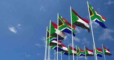 Sudan e Sud Africa bandiere agitando insieme nel il cielo, senza soluzione di continuità ciclo continuo nel vento, spazio su sinistra lato per design o informazione, 3d interpretazione video