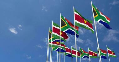 Suriname and South Africa Flags Waving Together in the Sky, Seamless Loop in Wind, Space on Left Side for Design or Information, 3D Rendering video