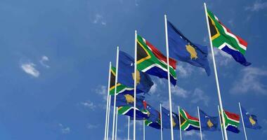 kosovo e Sud Africa bandiere agitando insieme nel il cielo, senza soluzione di continuità ciclo continuo nel vento, spazio su sinistra lato per design o informazione, 3d interpretazione video