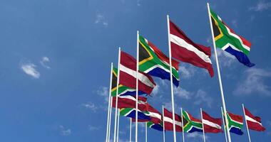 Latvia and South Africa Flags Waving Together in the Sky, Seamless Loop in Wind, Space on Left Side for Design or Information, 3D Rendering video