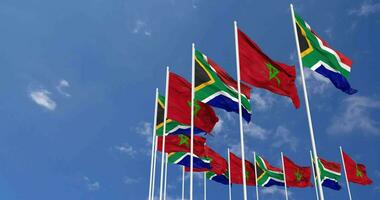 Marocco e Sud Africa bandiere agitando insieme nel il cielo, senza soluzione di continuità ciclo continuo nel vento, spazio su sinistra lato per design o informazione, 3d interpretazione video